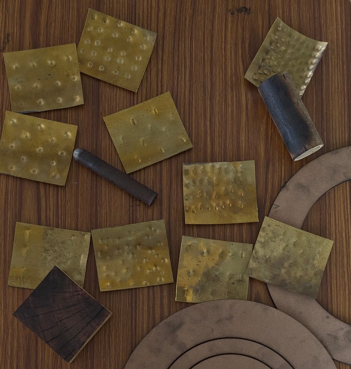 Brass test sheets with different hammered dot and dash patterns, a hammering punch and MDF ring templates