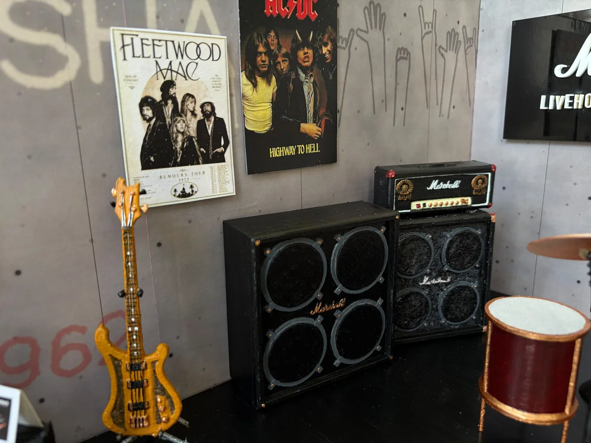 Close-up of the model: the bass, a Marshall amp stack and the drums under band posters