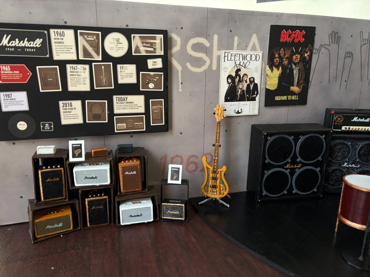 The model's history wall over the speaker crates, with the bass and the amp stack