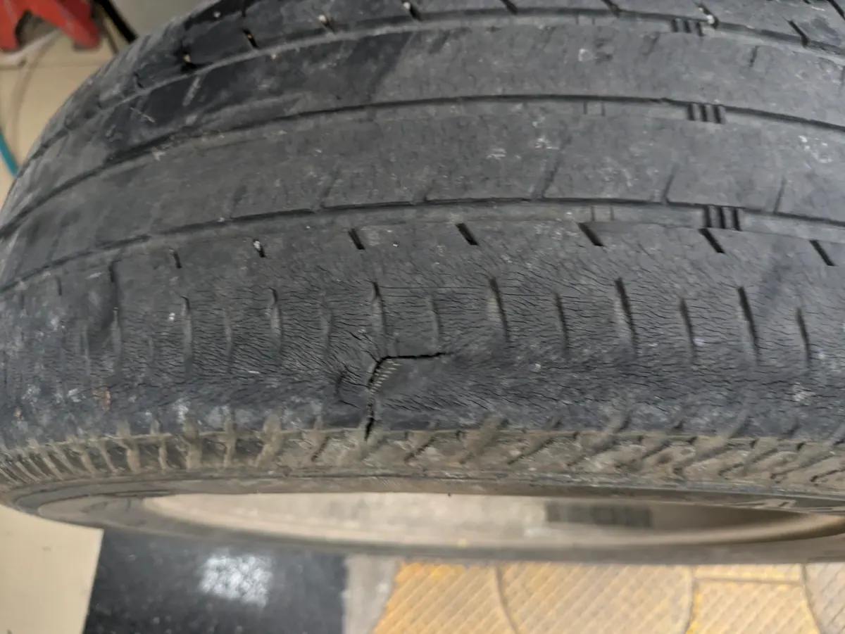 A worn tyre with a crack at the shoulder, where the tread meets the sidewall